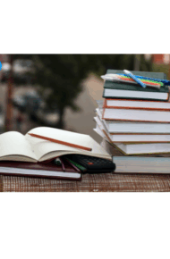 Pile di libri con quaderno aperto, calcolatrice e penne, ambientati all'aperto. In alto a sinistra, logo dell'istituto con globo